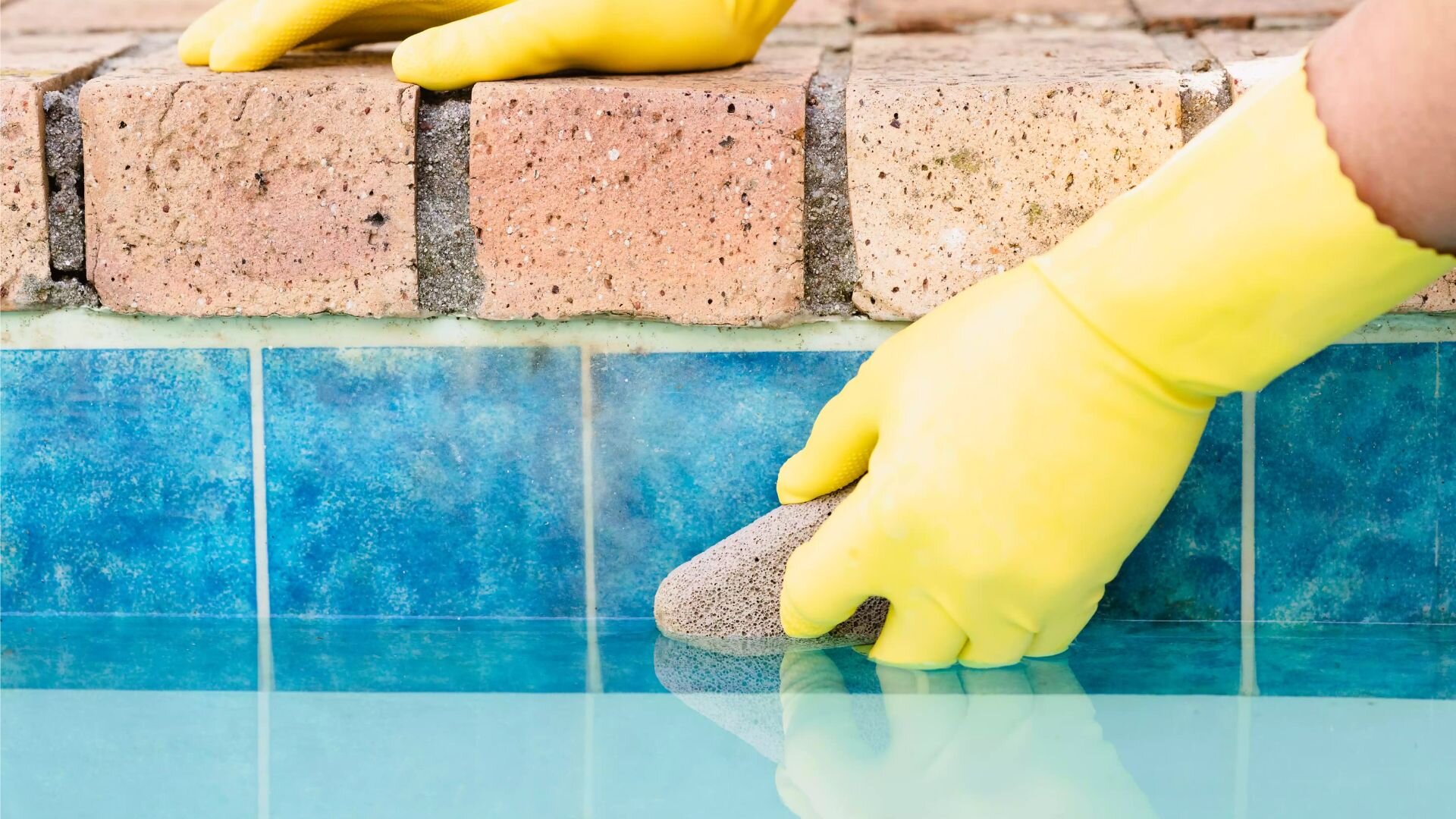 2023 07 Cleaning Pool Tiles With Yellow Glove Cleaning Pool Tiles Yellow Glove